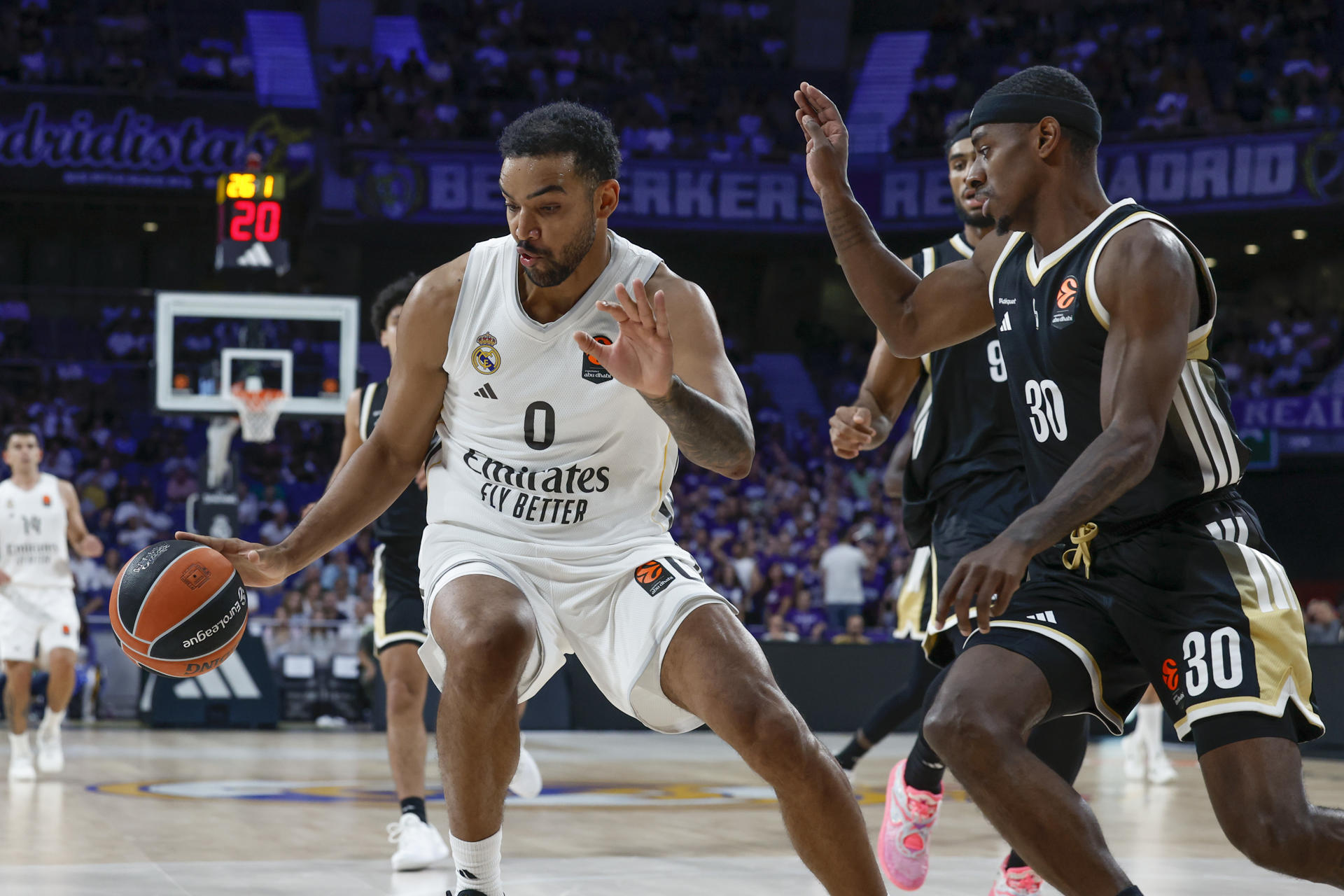 El ala pívot canadiense del Real Madrid Trey Lyles (i) intenta superar al base estadounidense del Asvel Villeurbanne Glynn Watson (d) durante el partido de la tercera jornada de la temporada regular de la Euroliga que disputan este jueves en el Movistar Arena de Madrid. EFE/Juanjo Martín