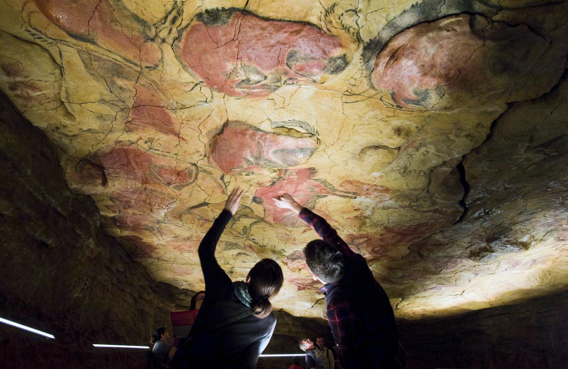 Turistas contemplando las pinturas rupestres en la réplica de las Cuevas de Altamira, en la localidad cántabra de Santillana del Mar. EFE/Archivo/Alberto Aja