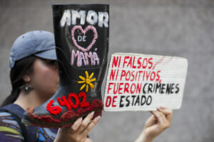 Fotografía de archivo, tomad el 18 de noviembre de 2024, de un mujer al sostener una bota, durante una protesta simbólica contra el congresista Miguel Polo Polo, quien niega las cifras de las ejecuciones de civiles cometidas por el Ejército, casos conocidos como 'falsos positivos', en Bogotá (Colombia). EFE/Carlos Ortega