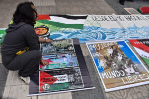 Una mujer coloca carteles durante una manifestación en apoyo a Palestina este martes, en Cochabamba (Bolivia). EFE/ Jorge Ábrego