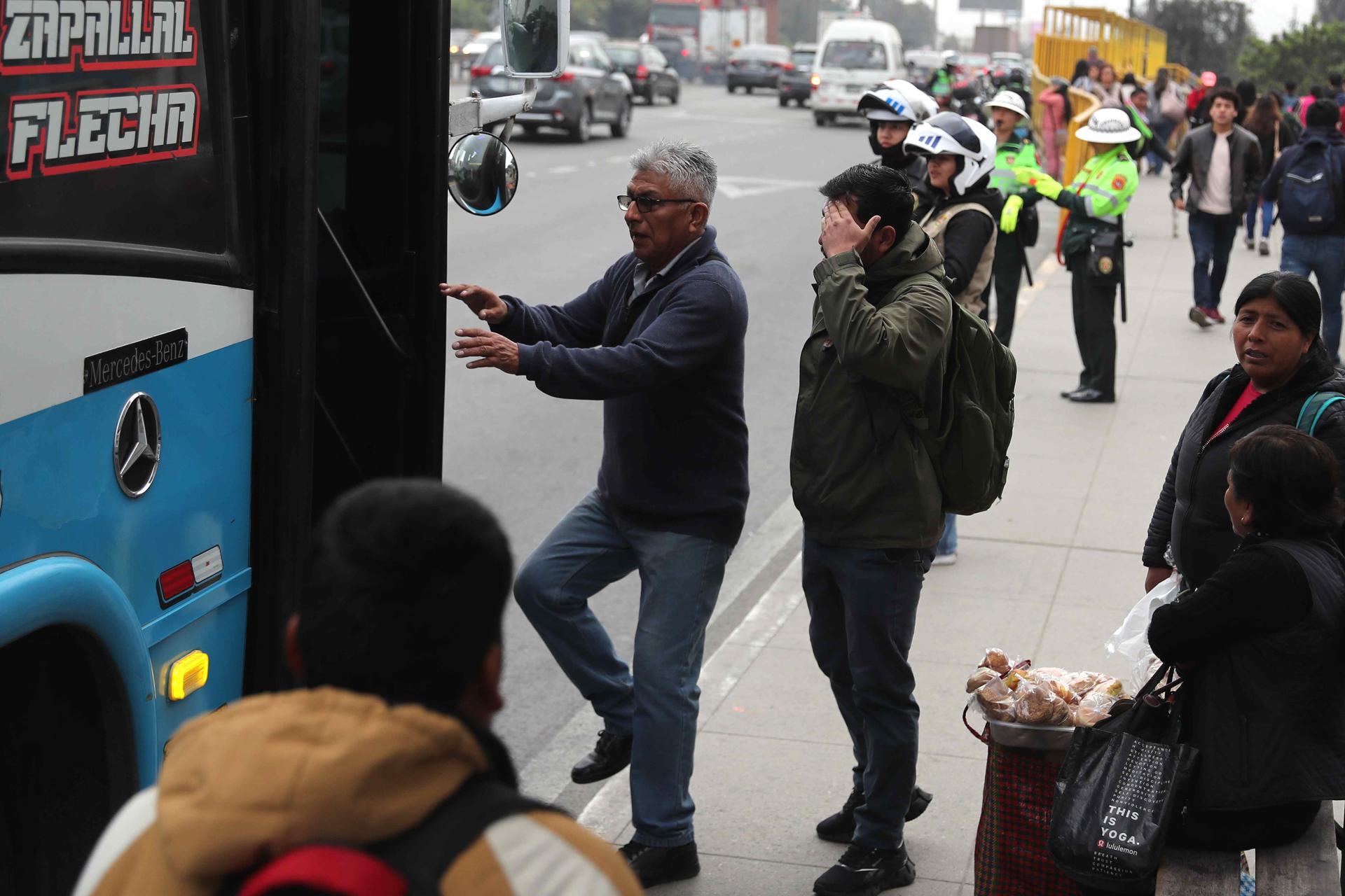 Personas intentan subir a un bus de servicio público este lunes, en Lima (Perú). EFE/ Paolo Aguilar
