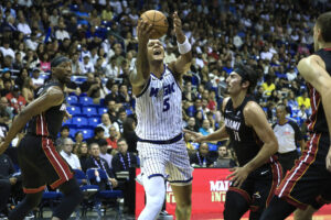 Paolo Benchero (c) de Orlando Magic se eleva entre jugadores del Miami Heat este sábado, en un partido de la pretemporada de la NBA jugado en en el Coliseo José Miguel Agrelot, de San Juan. EFE/ Thais Llorca