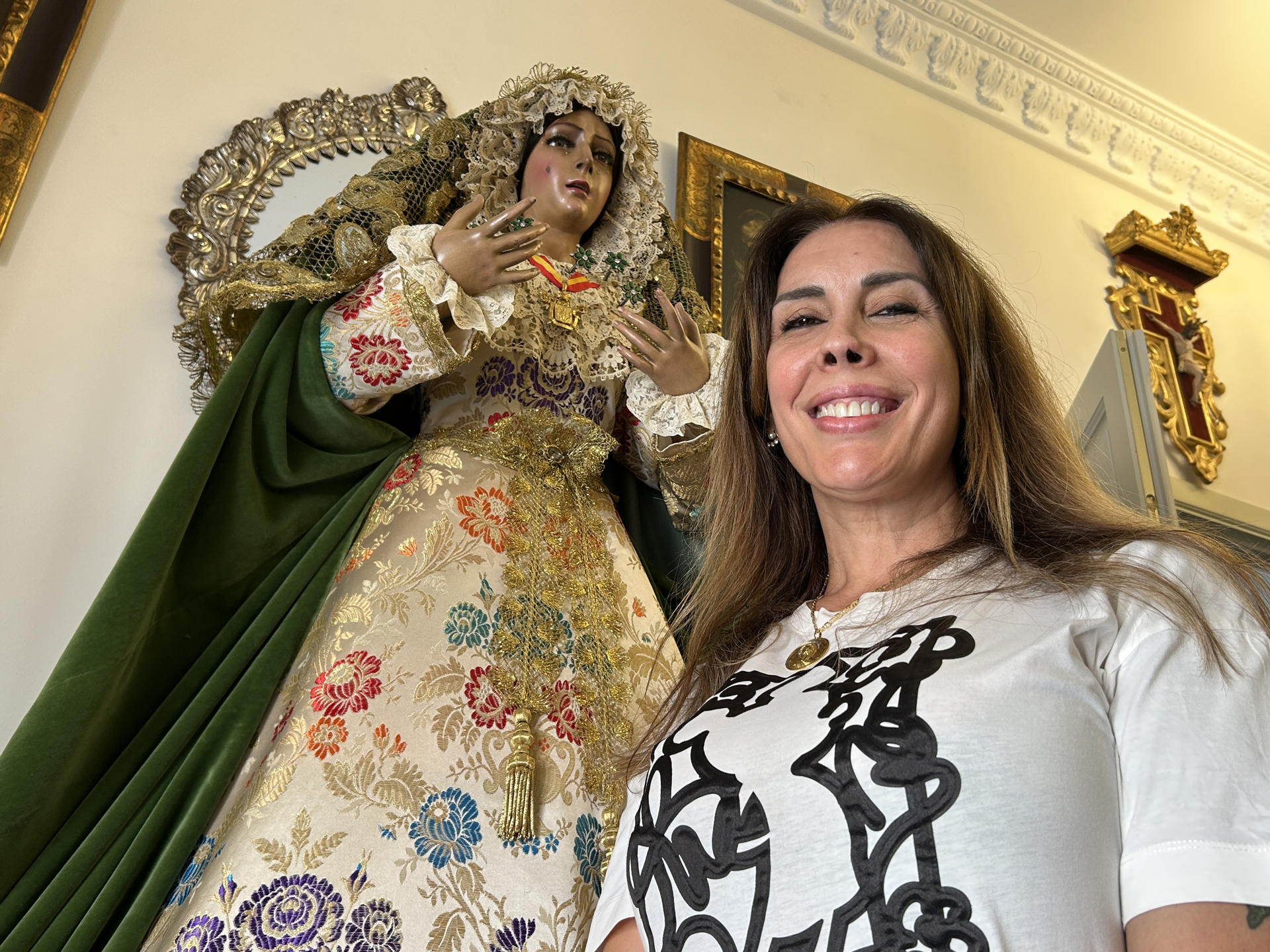 Ana Santamaría, una vecina de Camas (Sevilla), posa junto a la réplica de la Esperanza Macarena que tiene en una habitación de su casa que se ha transformado en un lugar de culto para muchas fieles que se consuelan mientras dura la restauración de la imagen visitando esta réplica casi a tamaño real de la virgen sevillana. EFE/Fermín Cabanillas
