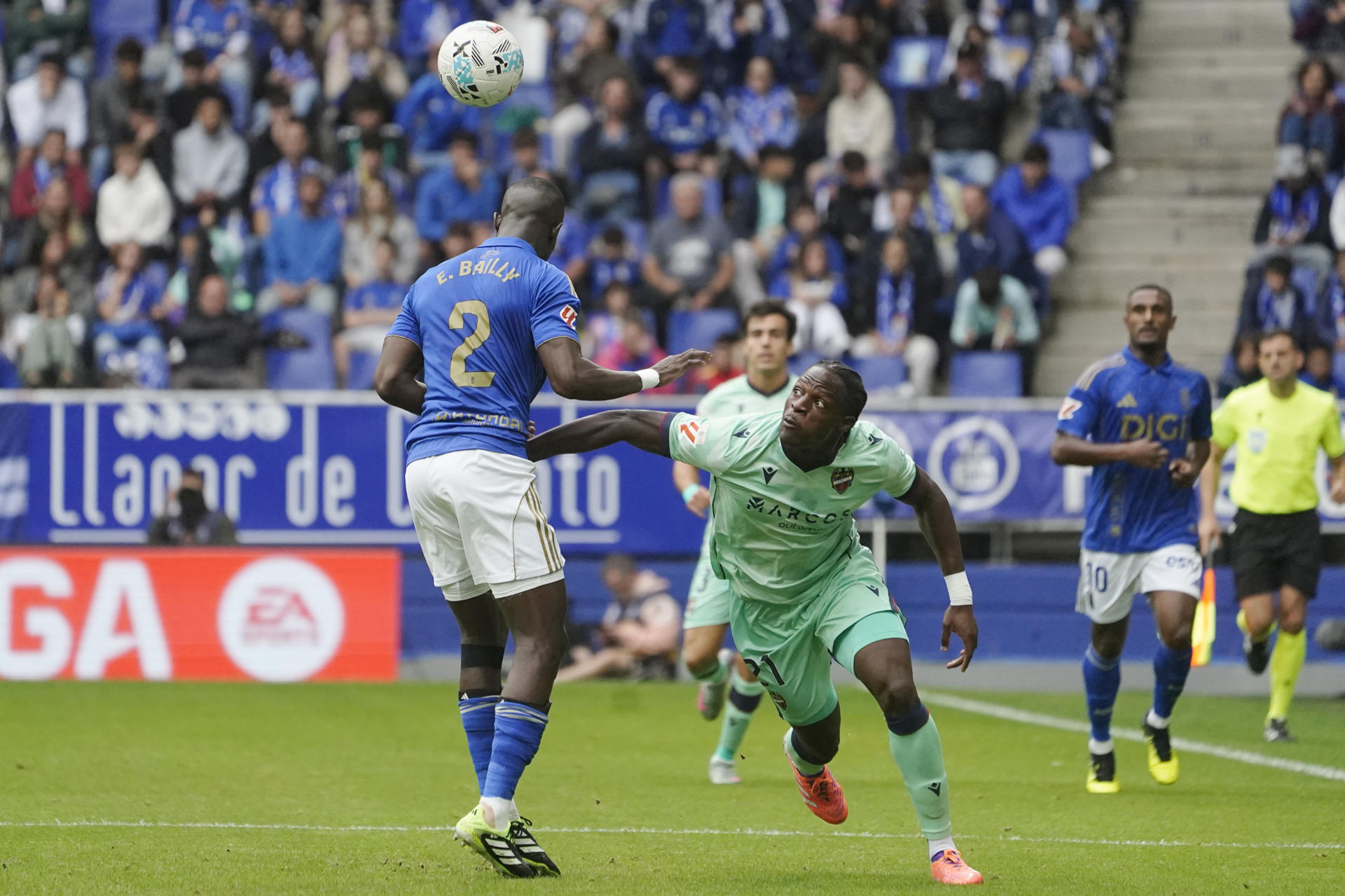 El delantero del Levante Karl Edouard Blaise Etta Eyong (d) lucha por el balón con el defensa del Real Oviedo Eric Bailly (i) durante el partido de LaLiga EA Sports disputado por ambos equipos este sábado en el Estadio Carlos Tartiere de Oviedo. EFE/ Paco Paredes
