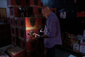 Un policía civil observa una botella de licor durante un operativo en una bodega de la zona sur de São Paulo (Brasil), en una fotografía del 2 de octubre de 2025. EFE/ Isaac Fontana