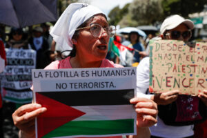 Una persona sostiene un cartel durante la segunda peregrinación por la paz en Palestina este domingo, en Quito (Ecuador). EFE/José Jácome