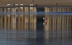 Unas mujeres pasean por la orilla de la playa de la Zurriola de San Sebastián. EFE/Juan Herrero.