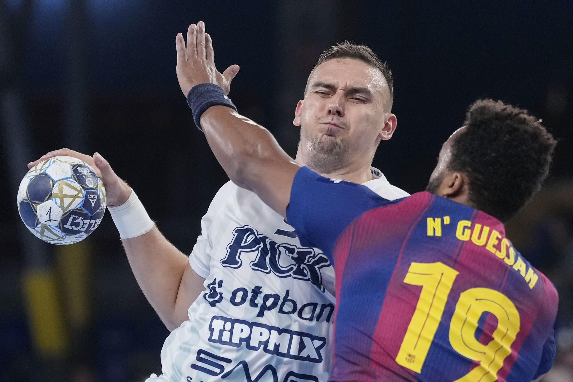 El extremo del OPT Bank Bodo Richard (i) intenta lanzar a puerta defendido por el francés Timothey N'Guessan (d), del Barça, durante el partido correspondiente a la temporada regular de la Liga de Campeones de Balonmano que Barça y OTP Bank-Pick Szeged disputan hoy jueves en el Palau Blaugrana. EFE/ Enric Fontcuberta.