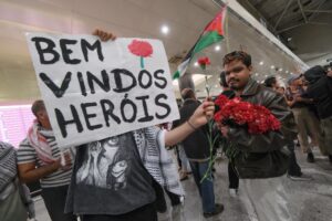 Seguidores esperan con una pancarta que dice: "Bienvenidos, héroes", mientras aguardan la llegada de los cuatro ciudadanos portugueses que participaron en la Flotilla Global Sumud. EFE/EPA/RUI MINDERICO