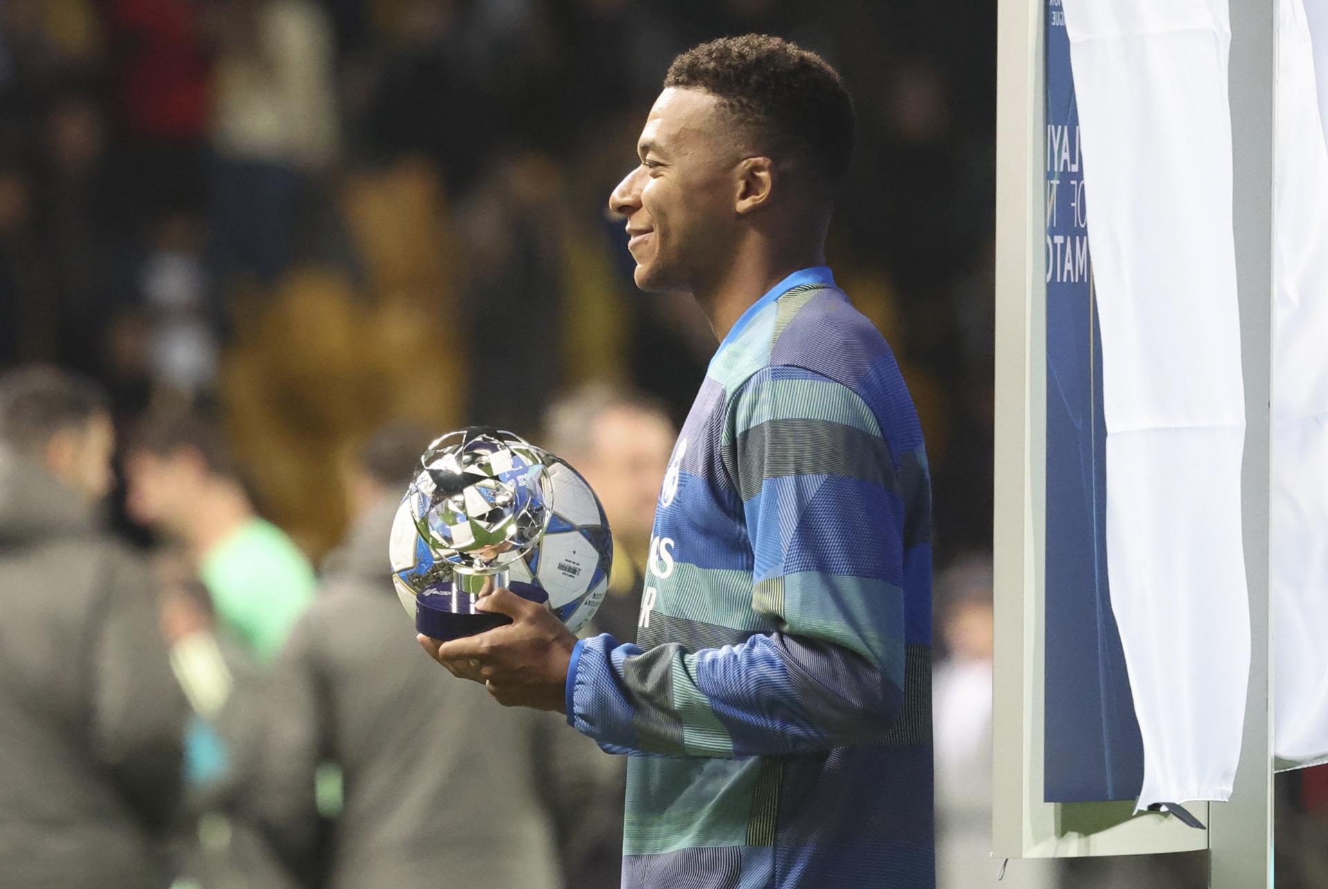 El jugador del Real Madrid Kylian Mbappe sostiene el balón del partido por su hat-trick y el trofeo de hombre del partido después de ganar el partido de la UEFA Champions League entre el Kairat Almaty y el conjunto blanco, en Almaty, Kazajistán. EFE/EPA/MAXIM SHIPENKOV