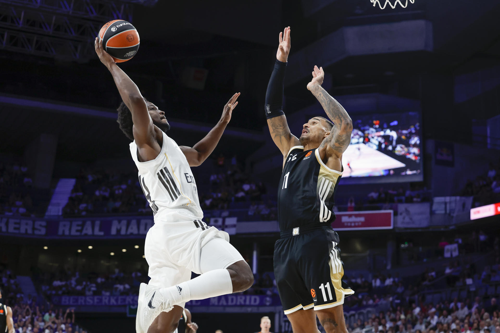 El base dominicano del Real Madrid Andrés Feliz (i) entra a canasta ante el escolta del Asvel Edwin Jackson durante el partido de la tercera jornada de la temporada regular de la Euroliga que disputan este jueves en el Movistar Arena de Madrid. EFE/Juanjo Martín