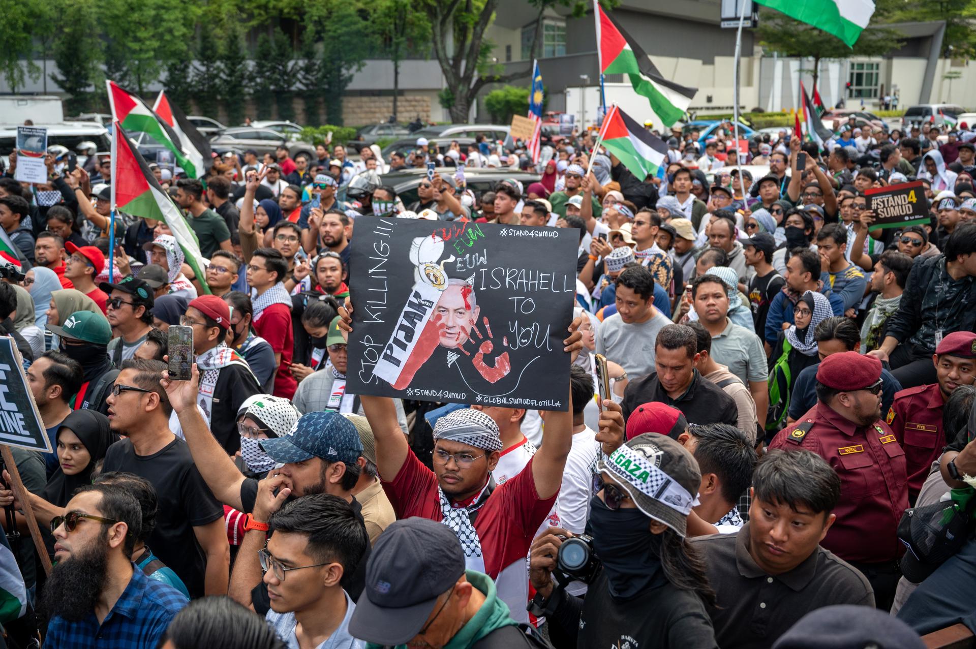 Kuala Lumpur (Malaysia), 02/10/2025.- Protesters wave Palestinian flags and hold placards during a demonstration against Israeli forces' interception of vessels from the Global Sumud Flotilla (GSF) and the detention of Malaysian activists, outside the US Embassy in Kuala Lumpur, Malaysia, 02 October 2025. Thousands of demonstrators gathered to protest Israel's interception of a Gaza-bound aid flotilla and the detention of at least 12 Malaysian activists. (Protestas, Malasia) EFE/EPA/NAZIR SUFARI

