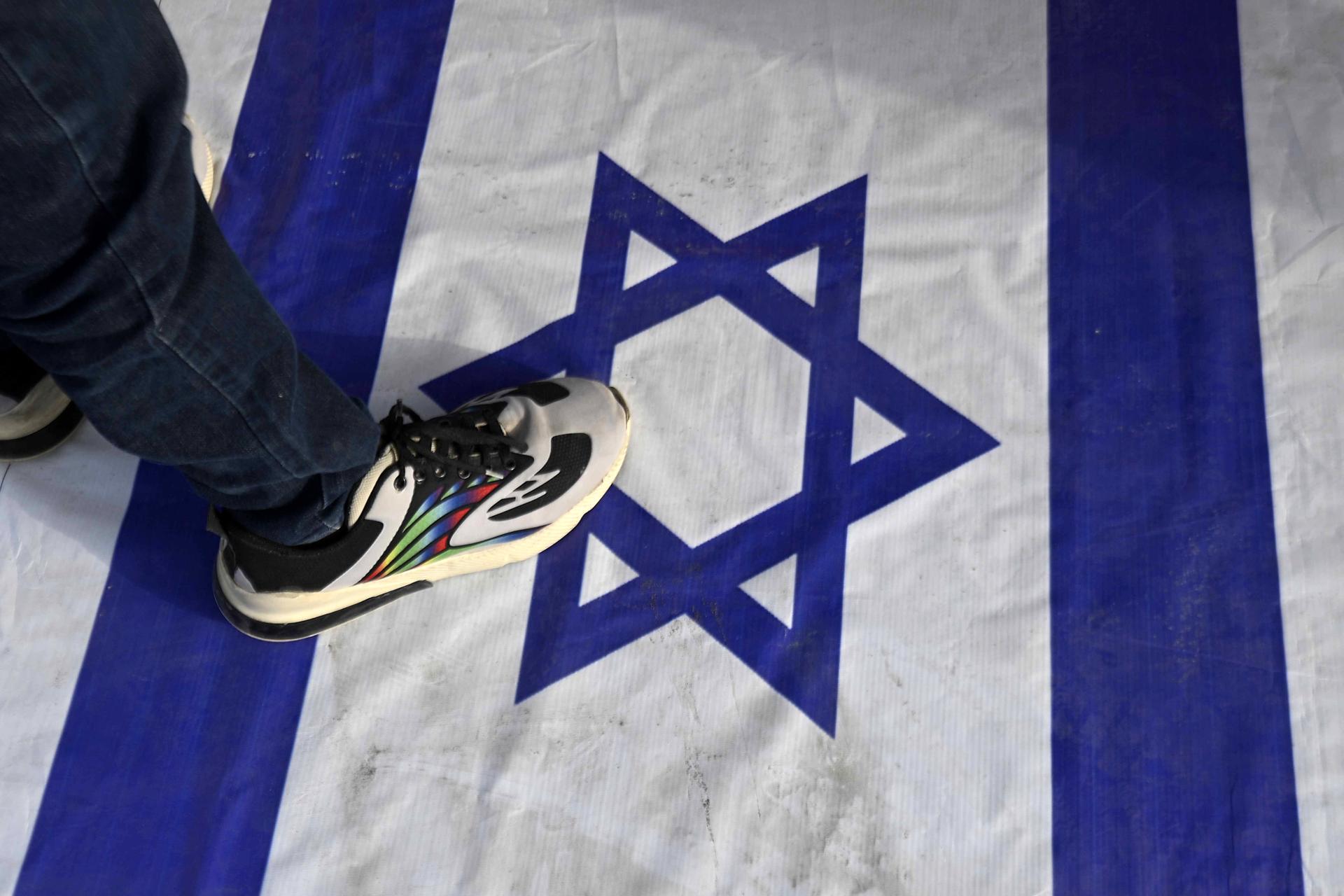 Un hombre se para sobre una bandera israelí durante una protesta en solidaridad con el pueblo palestino en Karachi, Pakistán, 07 de octubre de 2025. El 7 de octubre marca el segundo aniversario de un ataque transfronterizo por parte de Hamas en Israel el 07 de octubre de 2023 que mató a aproximadamente 1,200 israelíes y lanzó una campaña militar israelí en respuesta en la Franja de Gaza que mató a más de 67,000 palestinos y destruyó el enclave palestino. (Protestas) EFE/EPA/SHAHZAIB AKBER