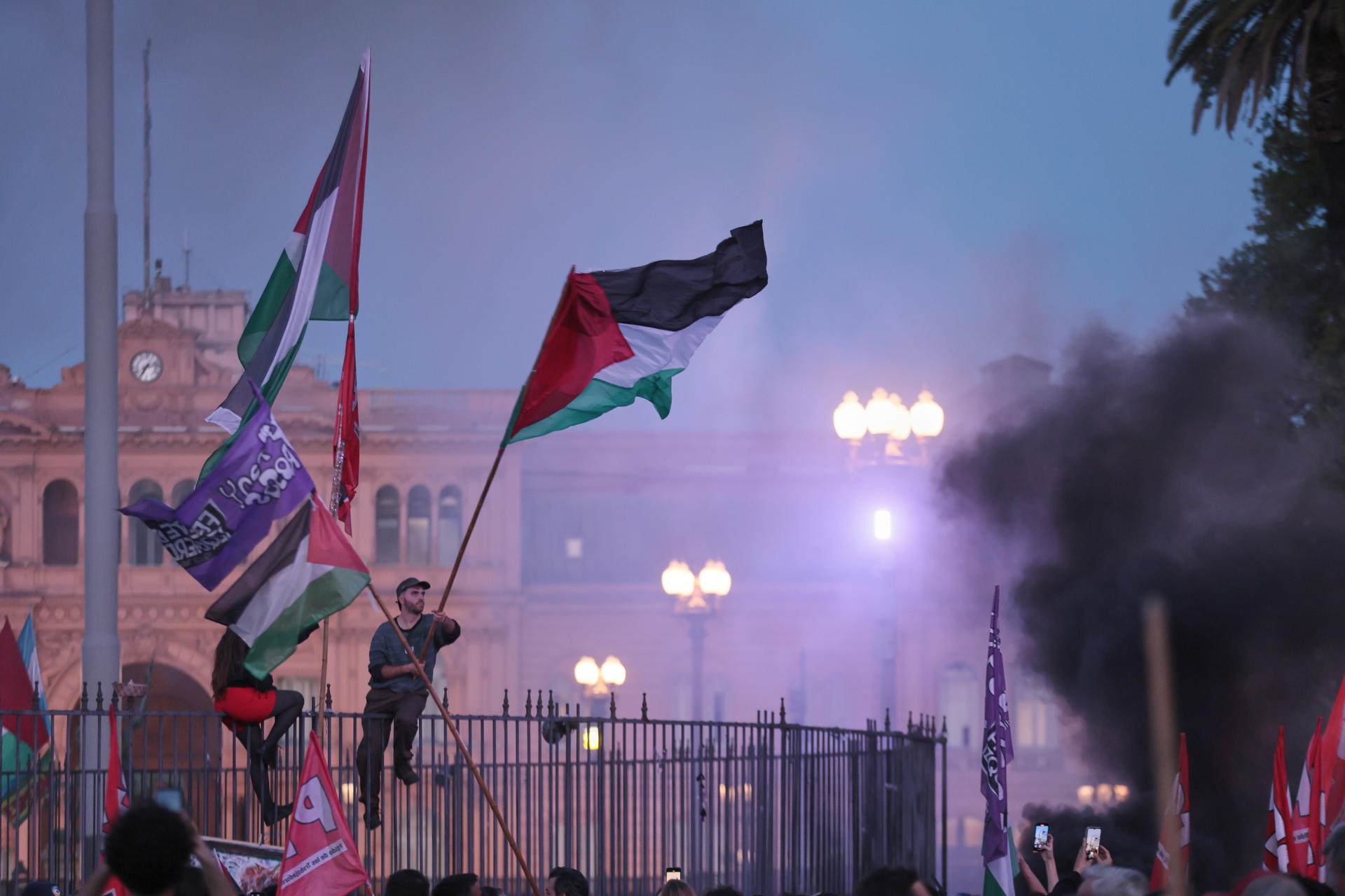 Personas sostienen banderas en una manifestación en apoyo a Palestina este martes, en Buenos Aires (Argentina). Miles de personas marcharon bajo la consigna "basta de genocidio" en la Franja de Gaza a dos años del ataque del grupo islamista Hamás contra Israel y el comienzo de la guerra en el enclave palestino. EFE/ STR
