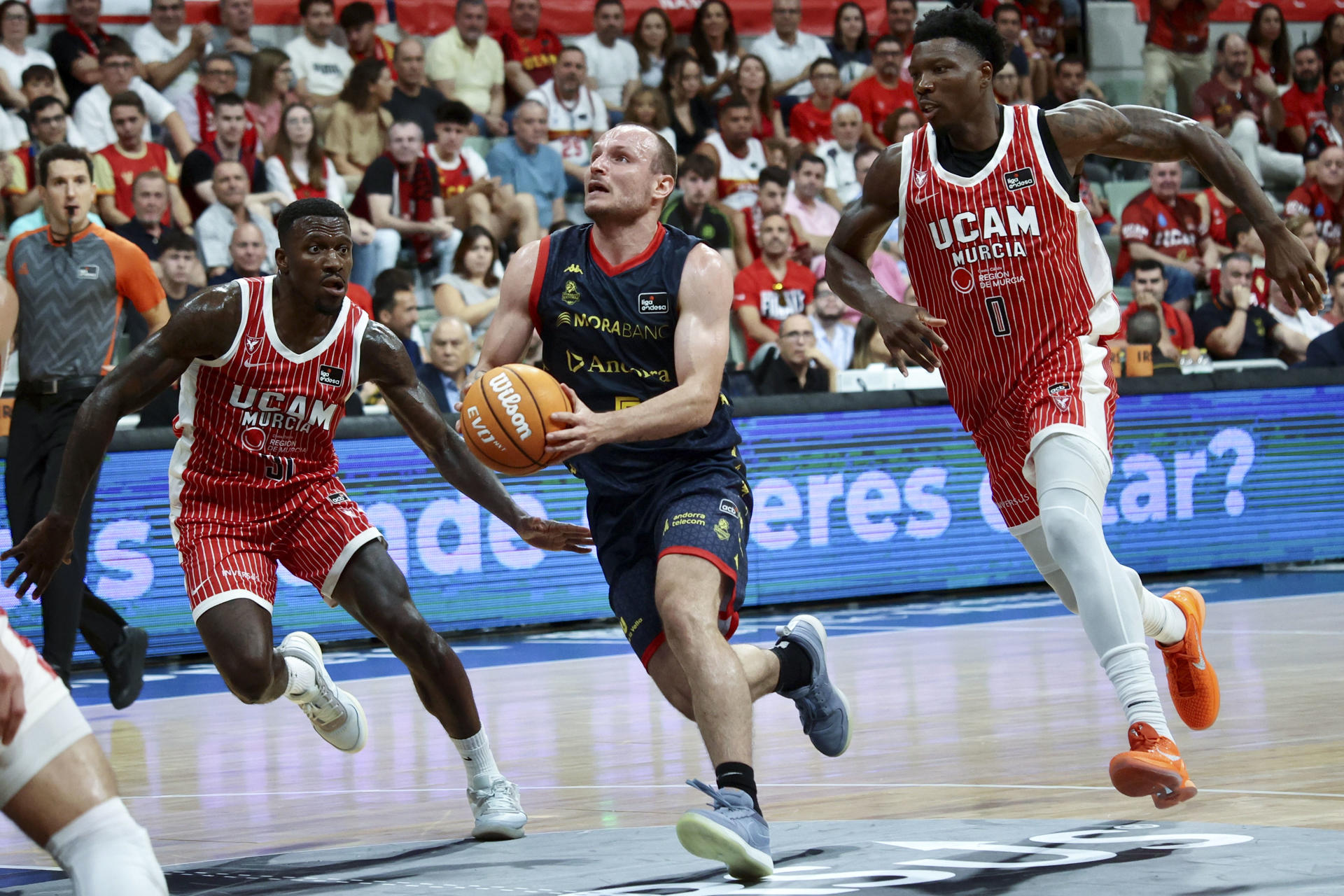 El base del Morabank Andorra Rafa Luz intenta escapar de los jugdores de UCAM Murcia Cacok y Ennisante durante el partido de Liga Endesa disputado ente el UCAM Murcia y el Morabank Andorra, este domingo en el Palacio de los Deportes de Murcia. EFE/ Juan Carlos Caval
