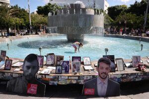 Personas colocando fotos de víctimas israelíes del ataque del 7 de octubre en la fuente de la plaza Dizengoff en Tel Aviv, Israel. EFE/ABIR SULTAN