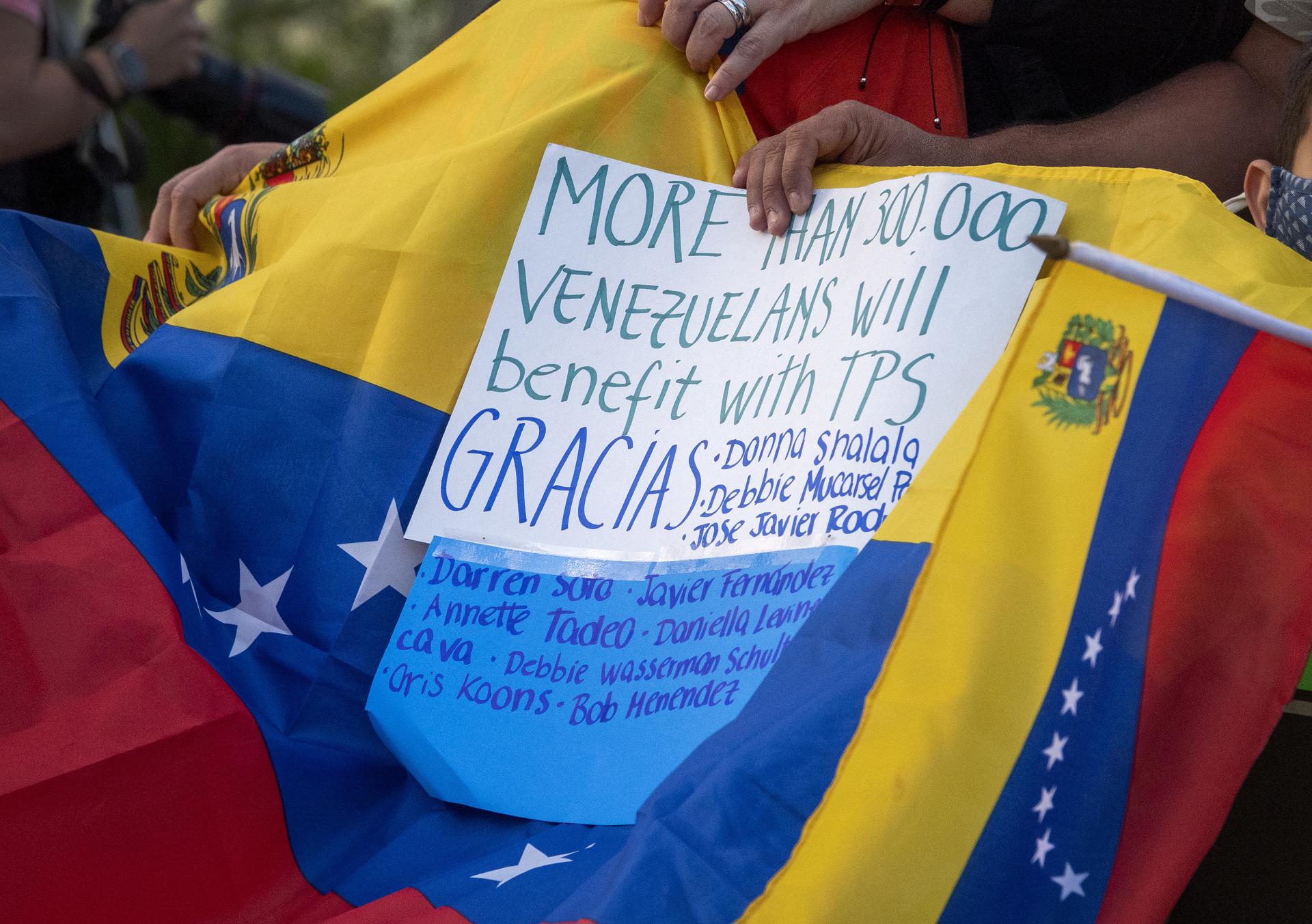 Fotografía de archivo, tomada en marzo de 2021, del detalle de un letrero sobre una bandera de Venezuela, en el que migrantes venezolanos celebraban la concesión del estatus de protección temporal (TPS) para más de trescientos mil de sus connacionales en Estados Unidos, en la ciudad de Doral (FL, EE.UU.). EFE/Cristóbal Herrera