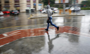 En la imagen de archivo, un joven corre bajo la lluvia en Valencia. EFE/ Kai Forsterling
