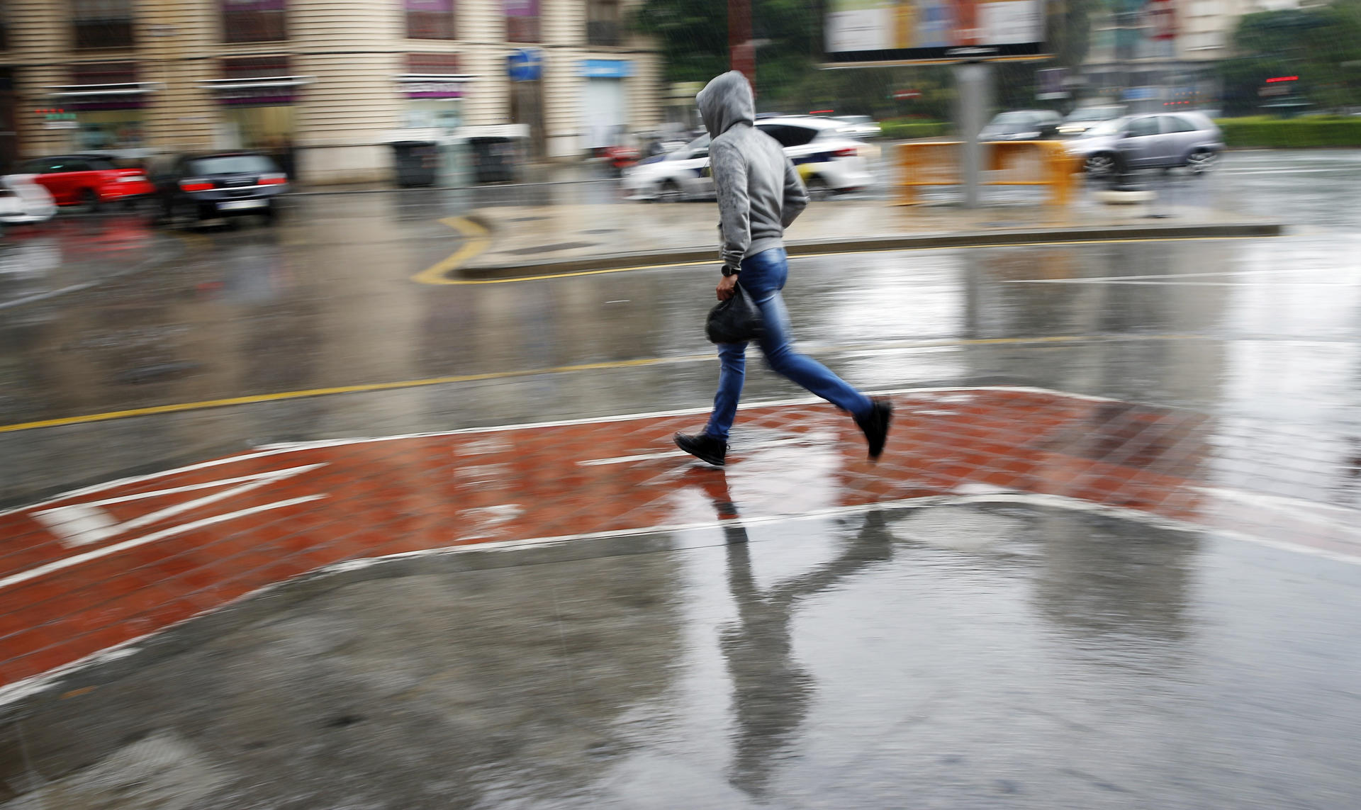 En la imagen de archivo, un joven corre bajo la lluvia en Valencia. EFE/ Kai Forsterling