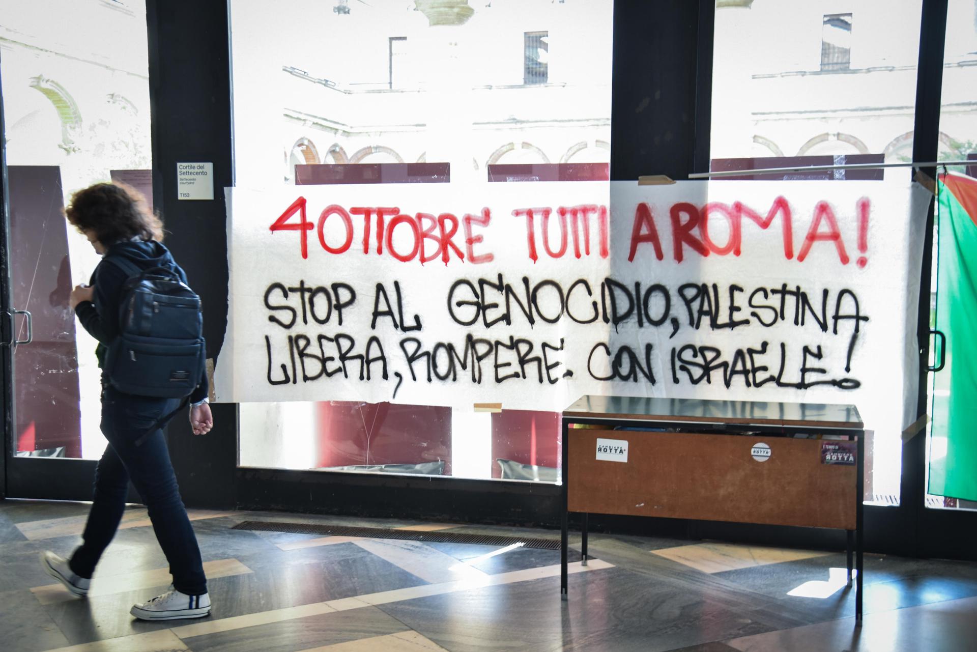 Una persona pasa junto a una pancarta que dice "¡4 de octubre, todos a Roma! ¡Alto al genocidio, Palestina libre, rompamos con Israel!" mientras estudiantes ocupan la Università Statale de Milán, en Milán, Italia, el 2 de octubre de 2025.(Protestas, Italia, Roma) EFE/EPA/MATTEO CORNER