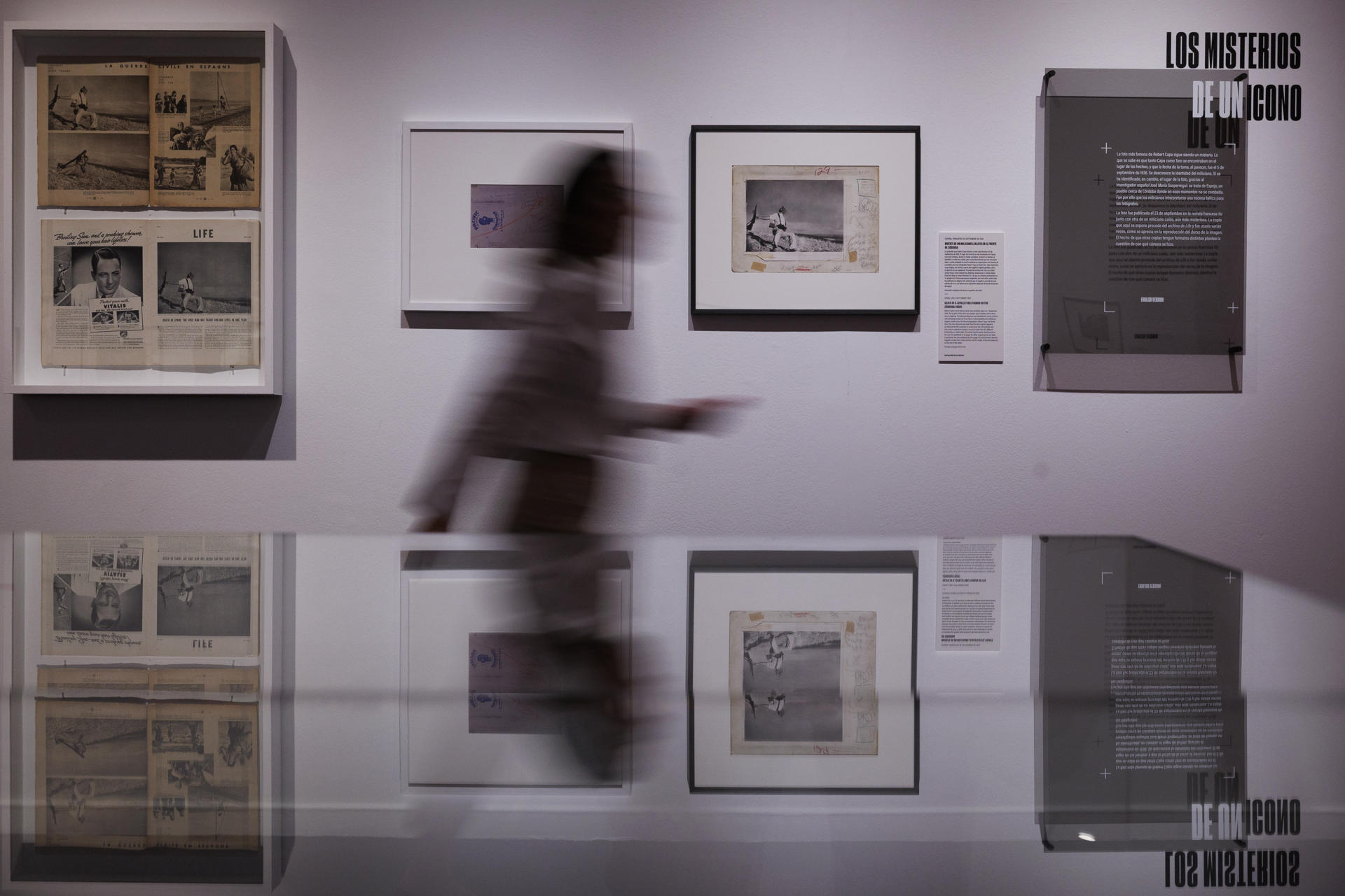 Una mujer pasa ante la famosa fotografía de la guerra civil española 'Muerte de un miliciano' y otras imágenes, que pueden verse en el Círculo de Bellas Artes de Madrid dentro de la exposición 'Robert Capa. ICONS', la mayor retrospectiva realizada en España dedicada al legendario fotógrafo. EFE/Sergio Pérez
