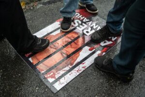 Kuala Lumpur (Malaysia), 03/10/2025.- Protesters step over a poster depicting Israeli Prime Minister Benjamin Netanyahu during a demonstration against the Israeli forces' interception of vessels from the Global Sumud Flotilla (GSF) and the detention of Malaysian activists, outside the US Embassy in Kuala Lumpur, Malaysia, 03 October 2025. Israel's interception of the flotilla, which was carrying aid supplies to Gaza Strip, and the detention of all those on board, including at least 23 Malaysian activists, has sparked international condemnation and protests. (Protestas, Malasia) EFE/EPA/NAZIR SUFARI