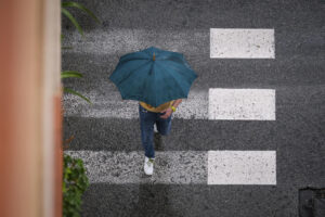Un hombre se protege de la lluvia en La Foia, en Elche, el jueves. EFE/ Pablo Miranzo