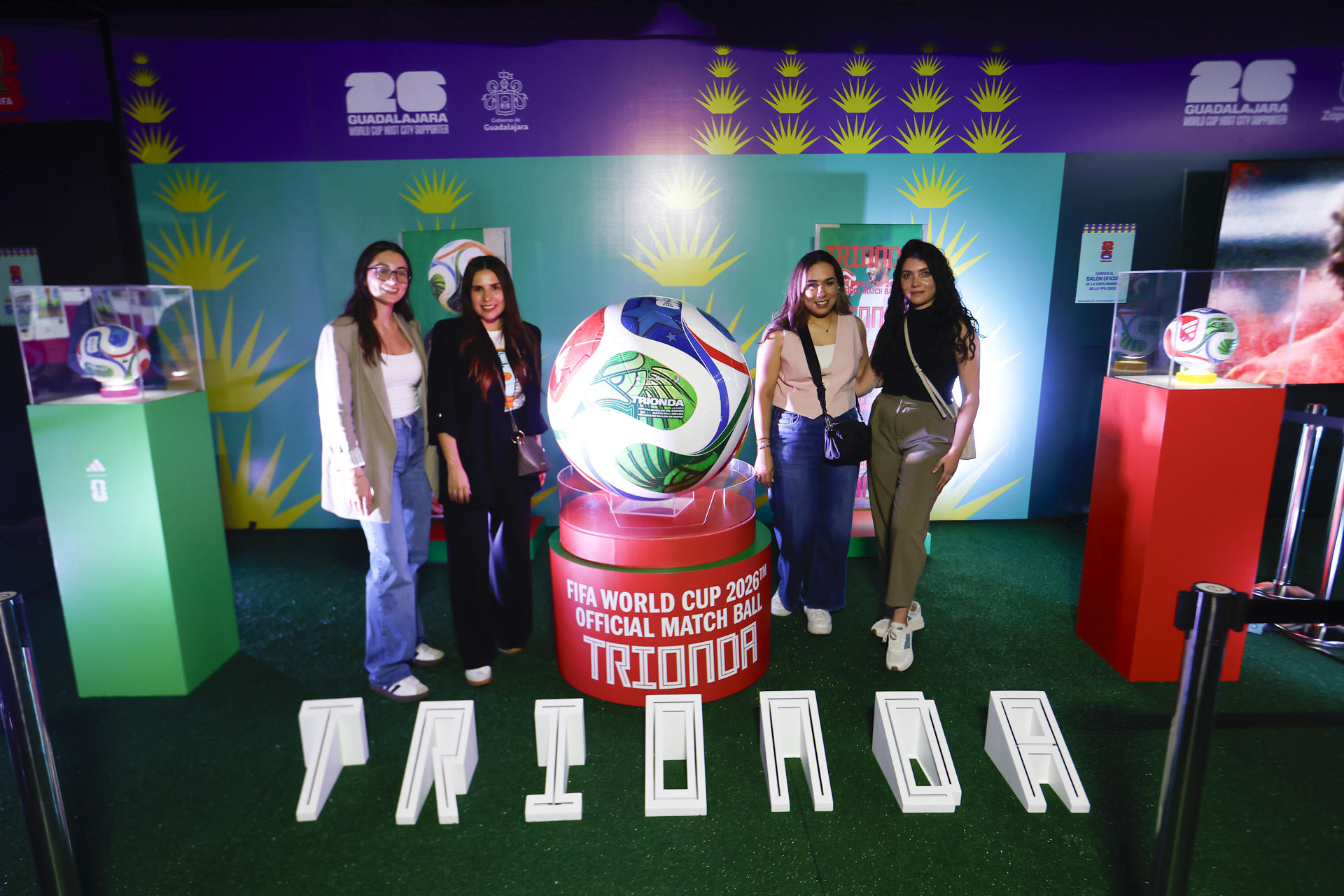 Personas posan junto al balón oficial de la Copa Mundial 2026 ‘Trionda’, durante la inauguración del pabellón 'El Alma del Mundial' este viernes, en Guadalajara (México). EFE/ Francisco Guasco
