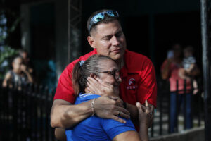 El periodista salvadoreño Mario Guevara (arriba) fue captado este viernes, 3 de octubre, al saludar a una mujer, en Apopa (El Salvador). EFE/ Rodrigo Sura