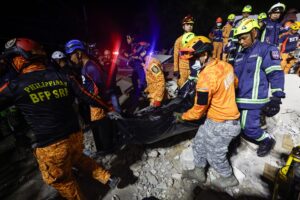 Rescatistas fueron captados este miércoles, 1 de octubre, al recuperar el cuerpo de una víctima del terremoto de magnitud 6.9 que en la víspera azotó el centro de Filipinas, en una instalación colapsada en la ciudad de Bogo. EFE/Rolex de la Pena