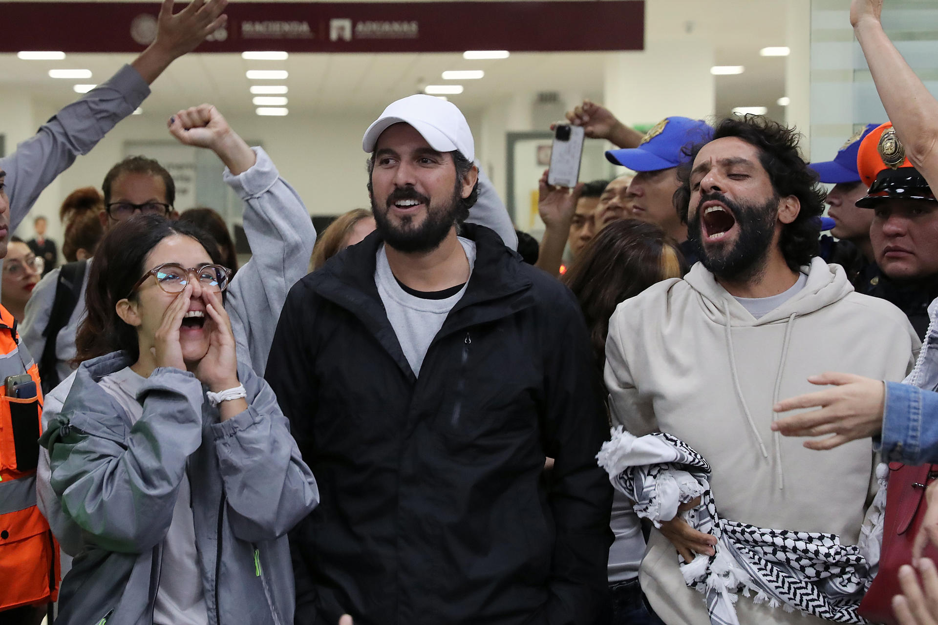 De izquierda a derecha, los activistas mexicanos Arlín Medrano, Carlos Pérez y Diego Vázquez reaccionan este miércoles, a su llegada al Aeropuerto Internacional de la Ciudad de México (México). EFE/Mario Guzmán