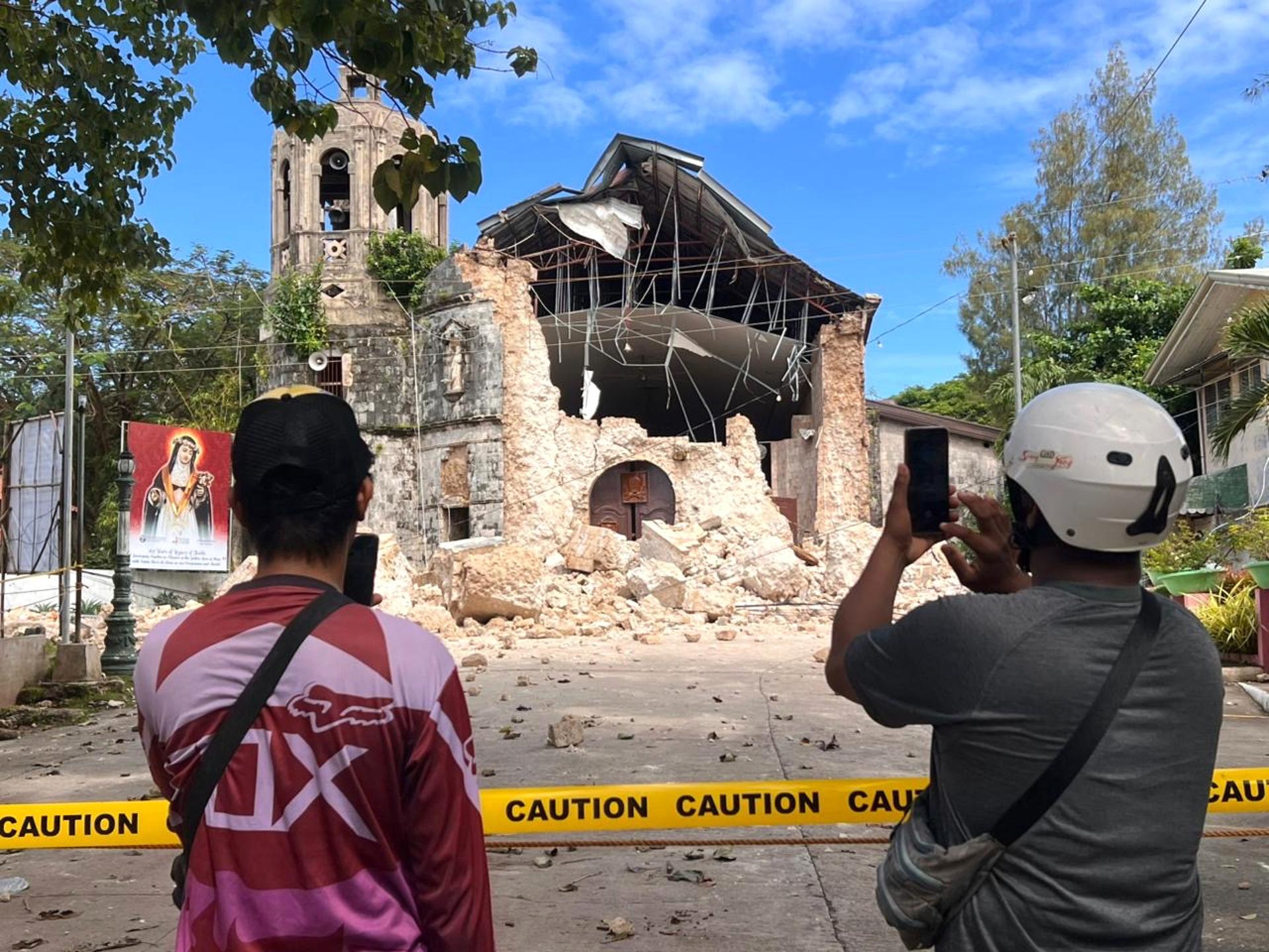 BOGO (Philippines), 01/10/2025.- People take pictures in front of a damaged church in the aftermath of an earthquake in Bogo city, Cebu island, Philippines, 01 October 2025. A magnitude 6.9 earthquake struck off the coast of Cebu island late on 30 September, with the epicenter in Bogo City, killing more than 60 people, according to Cebu Provincial Disaster Risk Reduction and Management Office (PDRRMO). (Terremoto/sismo, Filipinas) EFE/EPA/JUANITO ESPINOSA

