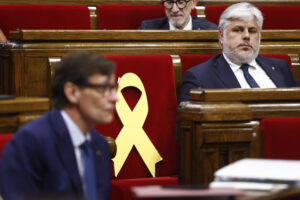 El presidente del grupo parlamentario de JxCat, Albert Batet, observa al presidente de la Generalitat, Salvador Illa, durante la segunda jornada del debate de política general, en la que el presidente catalán, Salvador Illa, mide el estado de sus relaciones con sus dos socios de investidura, ERC y Comuns, y con el resto de grupos parlamentarios de la oposición. EFE/Quique García