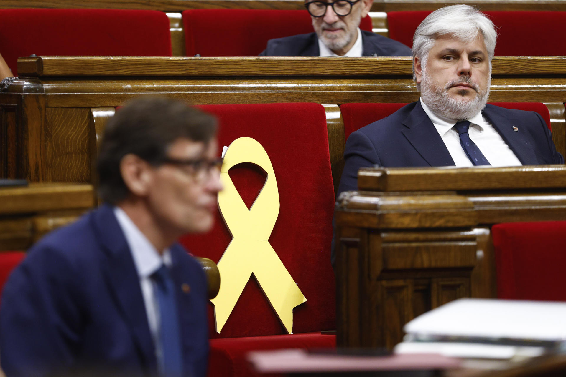 El presidente del grupo parlamentario de JxCat, Albert Batet, observa al presidente de la Generalitat, Salvador Illa, durante la segunda jornada del debate de política general, en la que el presidente catalán, Salvador Illa, mide el estado de sus relaciones con sus dos socios de investidura, ERC y Comuns, y con el resto de grupos parlamentarios de la oposición. EFE/Quique García