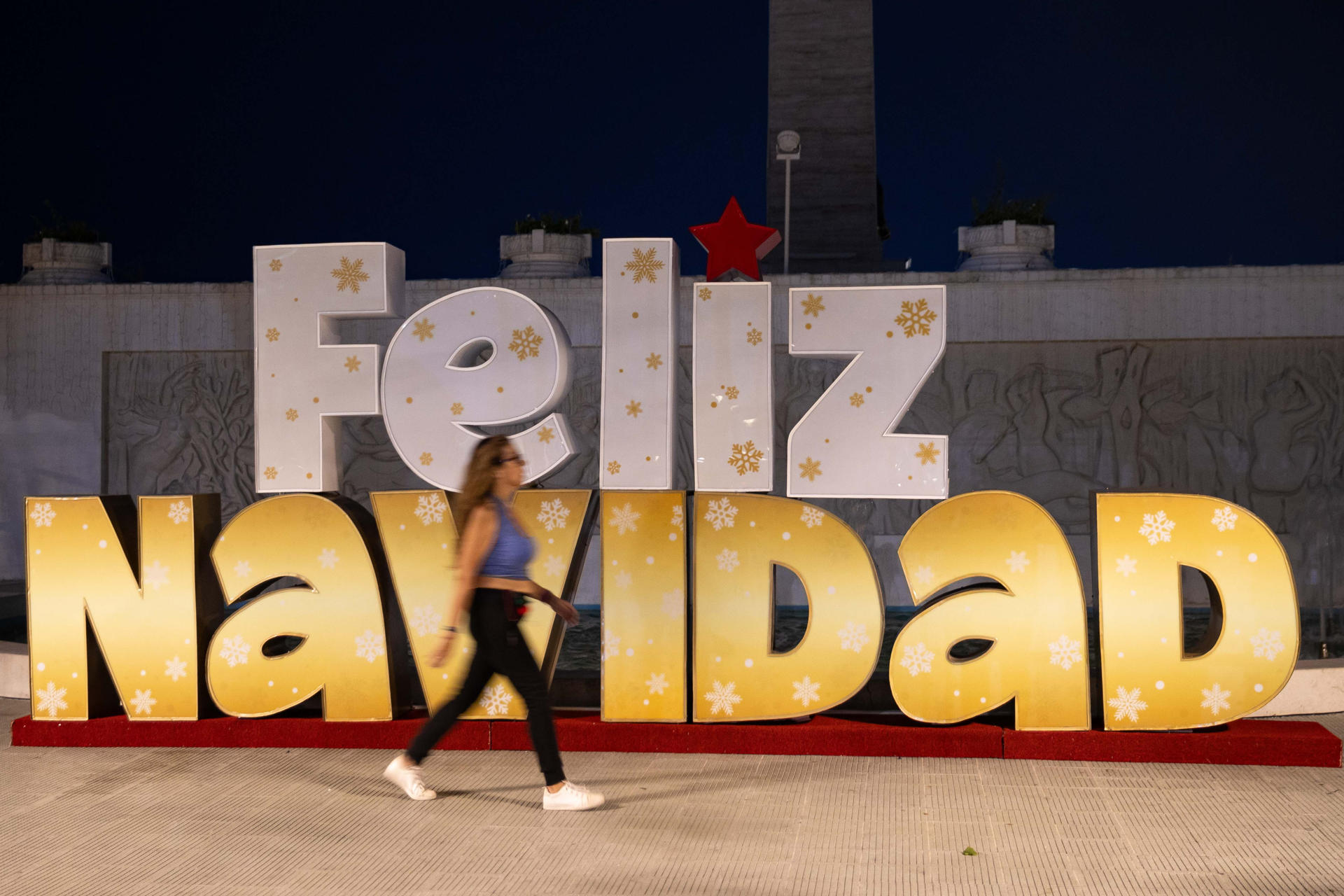 Una persona camina frente a decoración navideña este martes, en Caracas (Venezuela). EFE/ Ronald Peña R
