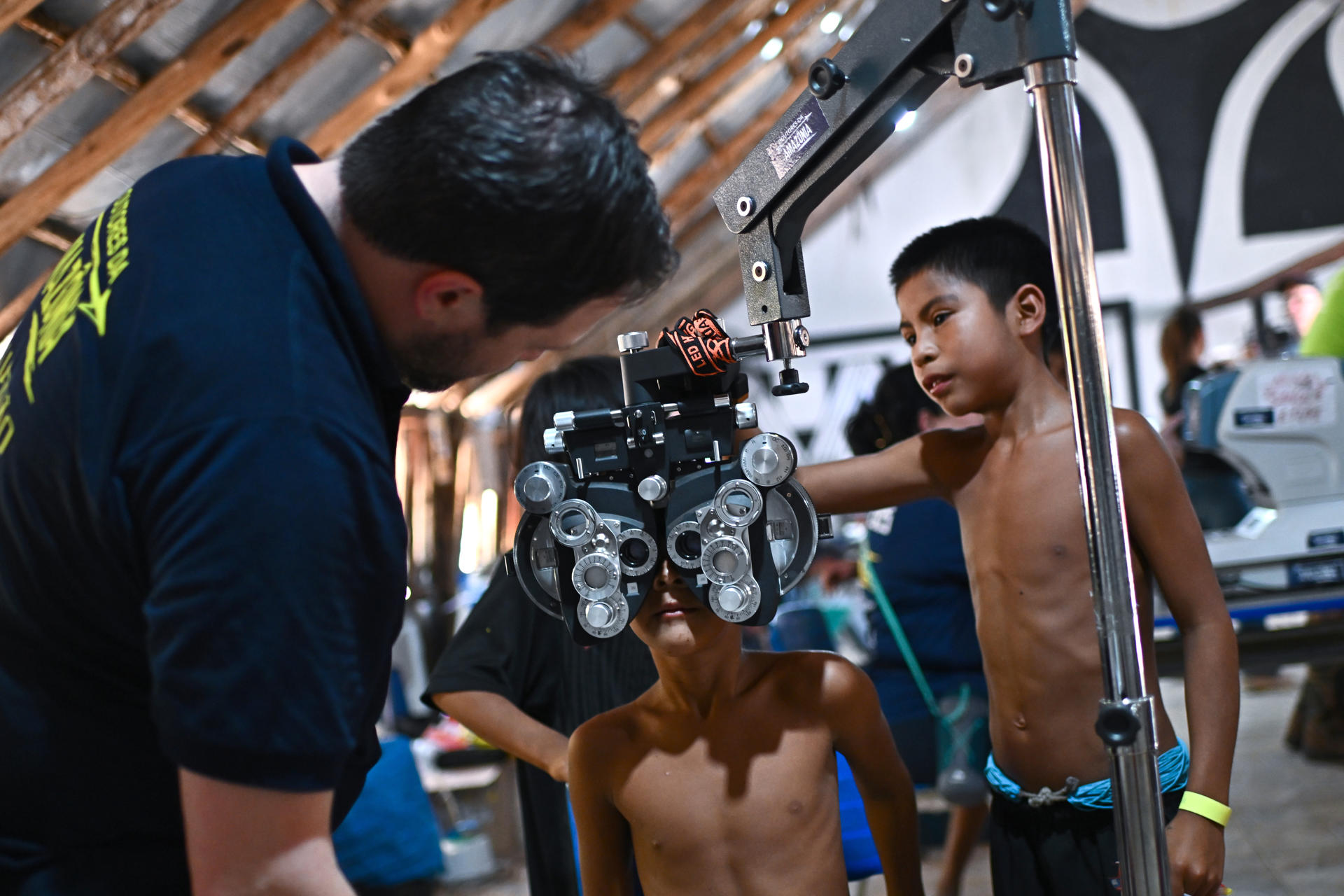 Un oftalmólogo voluntario examina a niños indígenas el 29 de septiembre de 2025 en la Aldea Kamayurá, del Parque Indígena Xingu, estado de Mato Grosso (Brasil). EFE/Andre Borges
