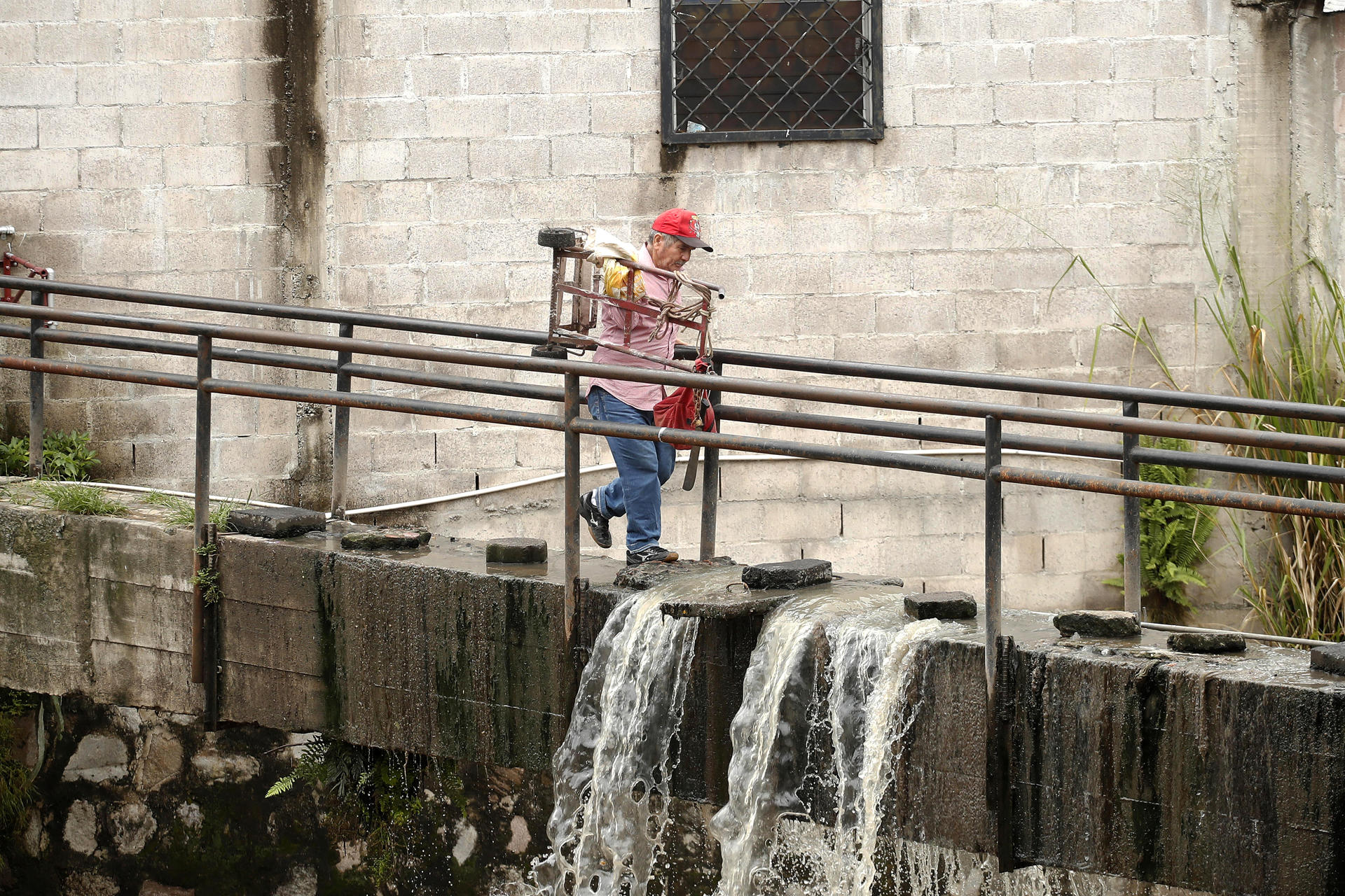 Un hombre cruza un puente este martes, en la comunidad Nicaragua, en San Salvador (El Salvador). EFE/ Rodrigo Sura

