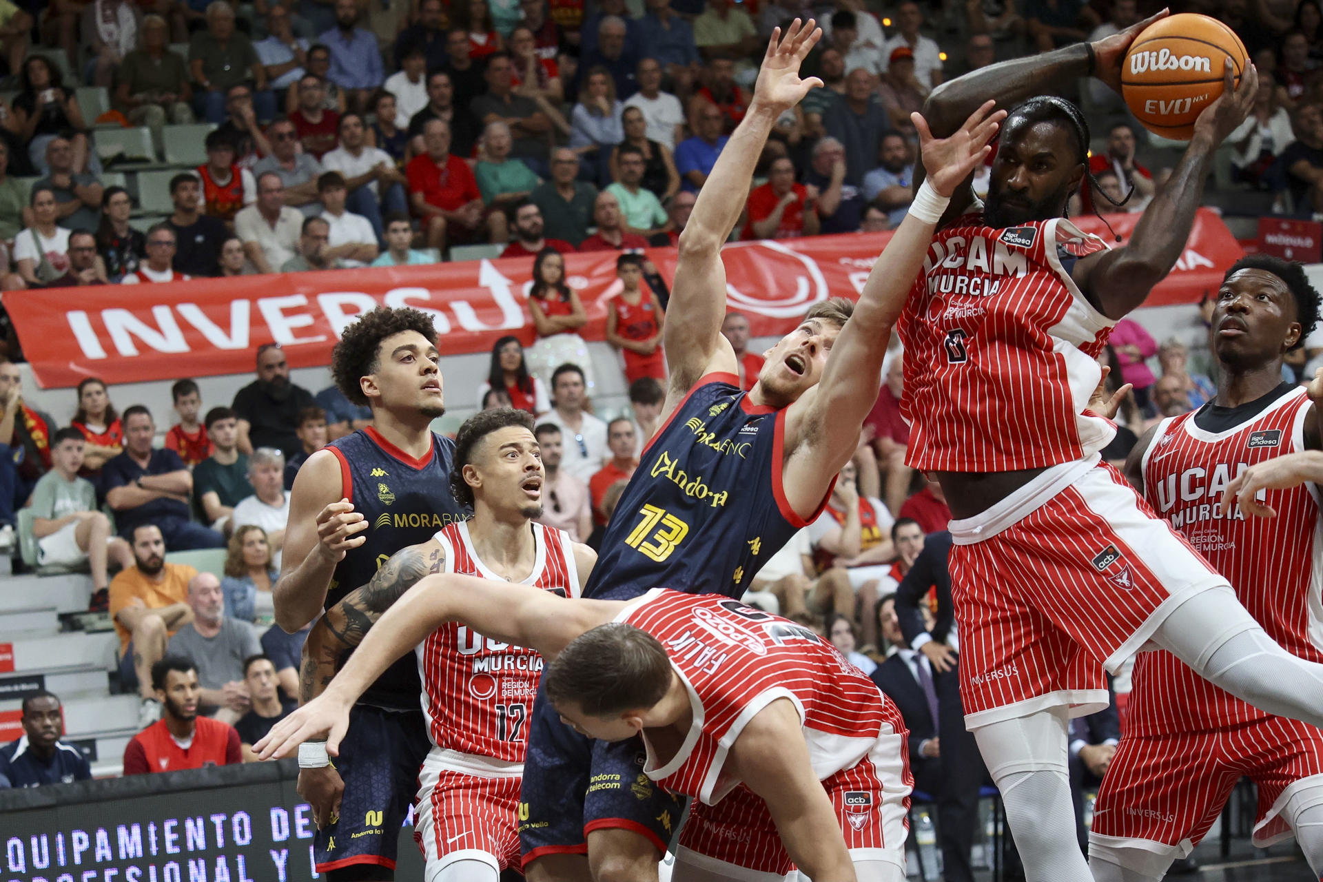 El escolta del Morabank AndorraChumi Ortega (c) ante los jugadores del UCAM Murcia durante el partido de Liga Endesa disputado ente el UCAM Murcia y el Morabank Andorra, este domingo en el Palacio de los Deportes de Murcia. EFE/ Juan Carlos Caval