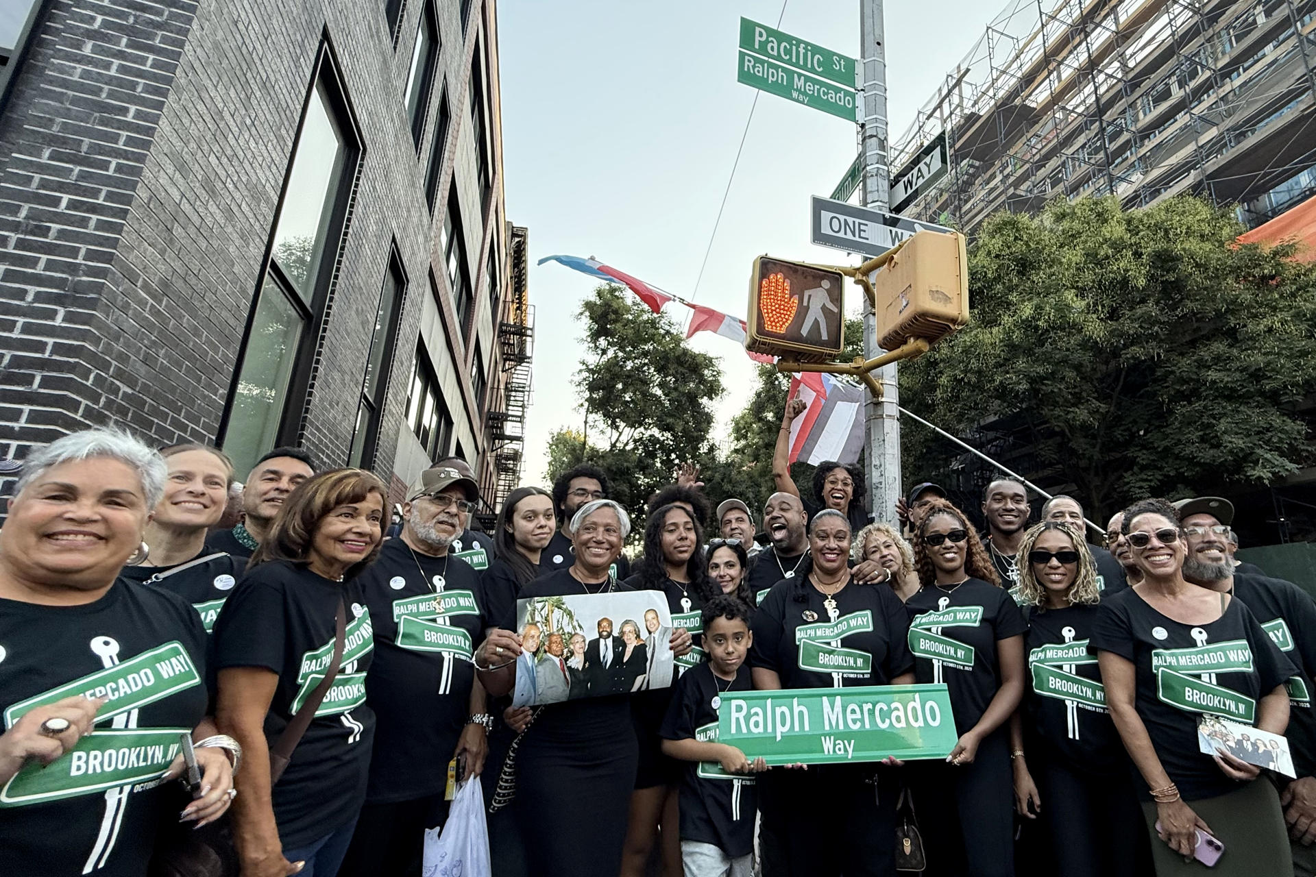 Fotografía cedida este domingo, 5 de octubre, por Eva Serebrinsky que muestra a familiares y amigos del legendario productor musical Ralph Mercado, al posar en la calle que ahora llevará el nombre del promotor artístico en Nueva York (NY, EE.UU.). EFE/Eva Serebrinsky