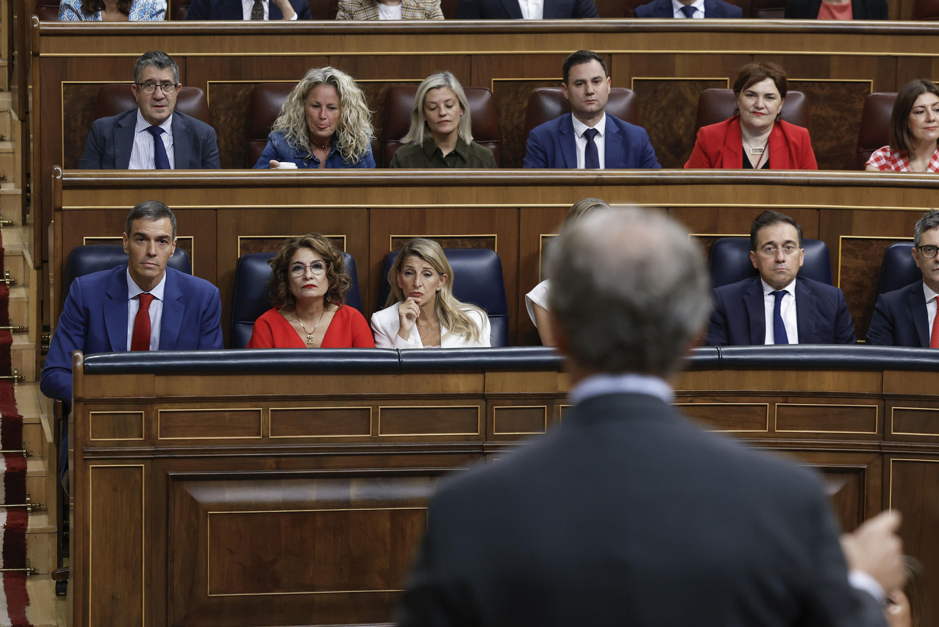 El presidente del Gobierno, Pedro Sánchez (i), escucha la intervención del líder del PP, Alberto Núñez Feijóo (de espaldas), durante la sesión de control al gobierno celebrada este miércoles en el Congreso. EFE/ Chema Moya
