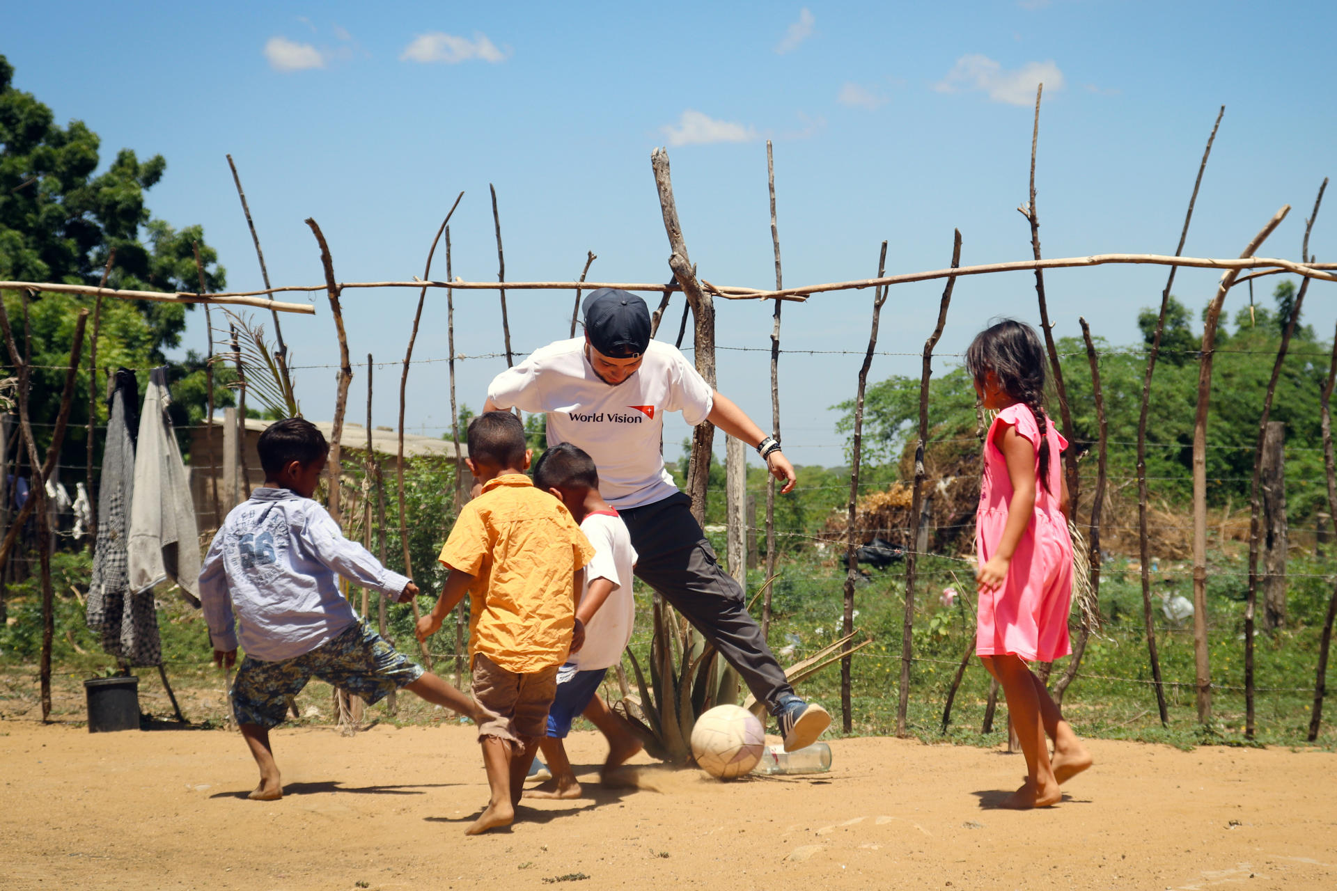 Fotografía sin fecha específica cedida por World Vision que muestra a una persona de la organización jugando fútbol con niños en La Guajira (Colombia). EFE/ Erica Bohorquez/ World Vision
