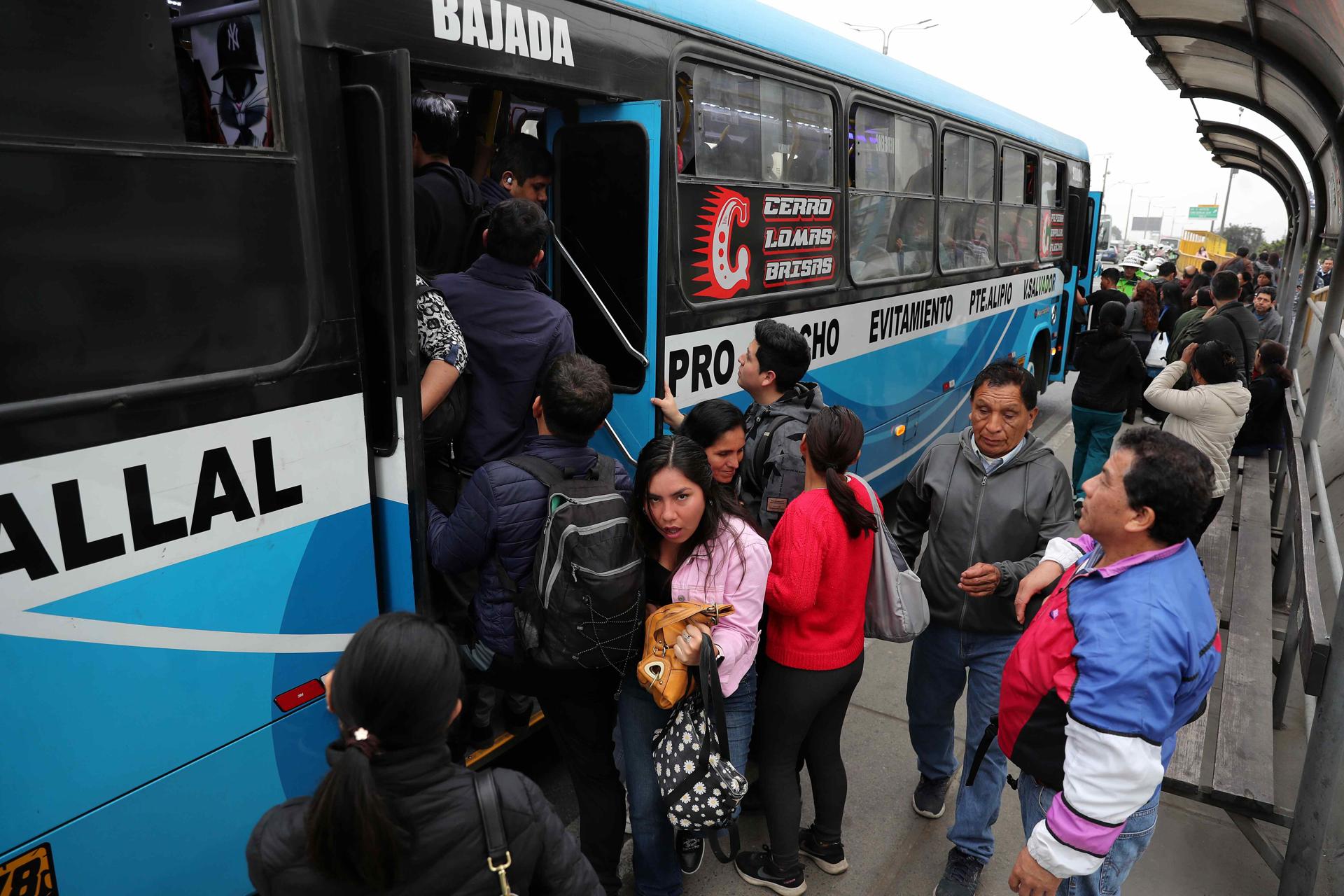 Personas intentan subir a un bus de servicio público este lunes, en Lima (Perú). EFE/ Paolo Aguilar