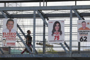 Una persona camina en un puente con carteles de campañas electorales este miércoles, en Tegucigalpa (Honduras). EFE/ Gustavo Amador