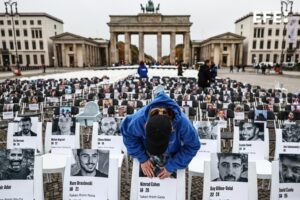 Una persona pega una foto en una silla durante una vigilia conmemorativa que marca el segundo aniversario del ataque de Hamas contra Israel, frente a la Puerta de Brandeburgo en Berlín, Alemania, el 07 de octubre de 2025. Más de 1,000 sillas con fotografías de víctimas y rehenes israelíes adjuntas a ellas se instalan en un memorial organizado por la Unión de Estudiantes Judíos de Alemania para recordar a las víctimas del ataque de Hamas. El 07 de octubre marca dos años desde que el grupo militante palestino Hamas lanzó un ataque sorpresa contra Israel, tomando decenas de rehenes y matando a casi 1,200 personas. En respuesta, Israel comenzó su guerra en Gaza, que ha matado a más de 66,000 personas, desplazado a millones y devastado el enclave palestino. (Protestas, Alemania) EFE/EPA/FILIP SINGER